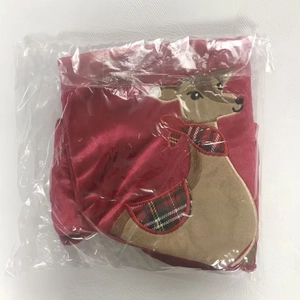 Detail of red velvet Christmas stocking with reindeer embroidery in plastic packaging
