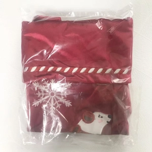 Detail of red satin Christmas stocking featuring white snowflake and bear embroidery