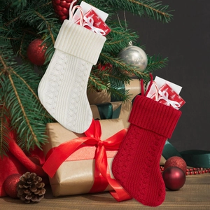 Detail of red and white knitted Christmas stockings with cable patterns for gifts