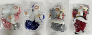 Four 12-inch sitting Santa Claus figures in pink, blue, grey, and red festive outfits