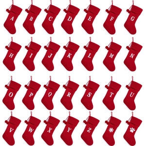 Red knitted Christmas stockings with white initials A-Z and hanging plush pom-poms
