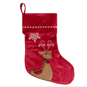 Red velvet Christmas stocking featuring a reindeer with candy cane antlers on white backdrop
