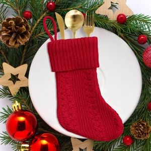 Red cable knit Christmas stocking used as a festive cutlery holder on a dinner plate