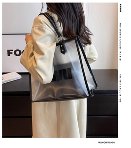 Detalle del bolso tote de PVC transparente con bolsa interior negra y asas dobles