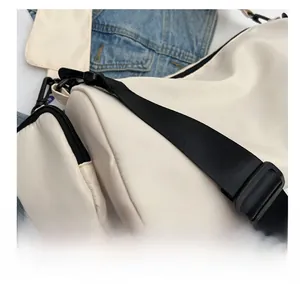 Detail of cream nylon crossbody bag with wide black strap and removable coin purse pouch