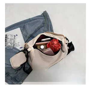 Spacious interior of beige nylon crossbody bag holding umbrella, phone and wallet