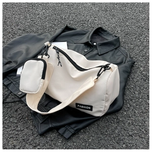 Close-up of off-white nylon pillow bag with detachable coin purse on a black leather jacket