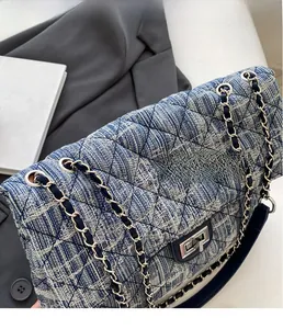 Detail of blue and white tweed crossbody bag featuring silver chain and quilted patterns