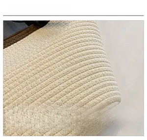 Macro shot of tightly woven cream fabric with deep brown edge piping detail on tote bag