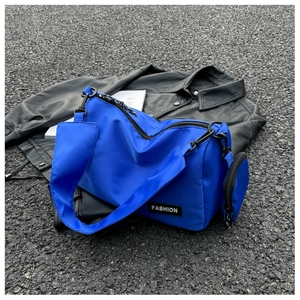 Detail of royal blue nylon crossbody bag with detachable coin purse and fashion tag