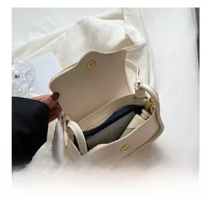 Internal view showing storage capacity for a phone and wallet in a cream crossbody bag