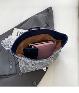 Top view of large denim tote bag interior showing a tablet and zipper pocket detail