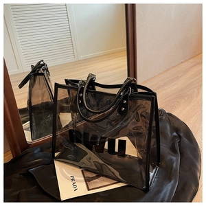 Detalle del bolso tote de PVC transparente con ribete negro y logotipo OWU impreso