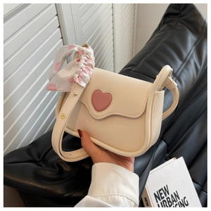 Detail of cream PU crossbody bag with scalloped flap pink heart and polka dot scarf strap