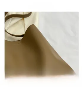 Close-up of brown leather bucket bag showing fine texture and smooth finish