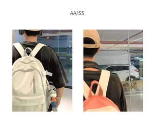 Detail view of large capacity casual backpacks in white and orange with cute keychain