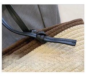 Detail view of bi-color woven fiber texture with minimalist black leather knotted strap