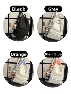 Detail view of large nylon backpack colors in black, gray, and blue with cute charms