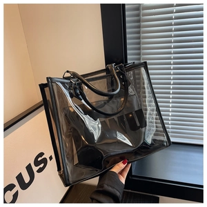 Detalle del bolso tote de PVC transparente con letras WU negras y adornos de cuero fino