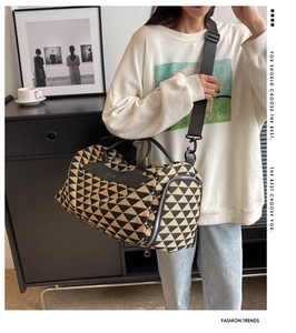 Détail du sac de voyage en toile à motifs géométriques avec poignées en cuir et bandoulière