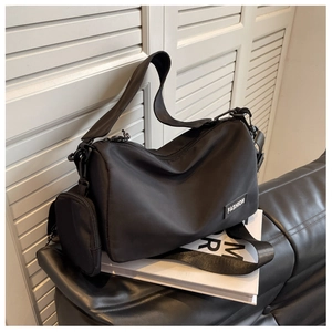 Detail of black nylon crossbody bag with side coin purse and fashion label patch