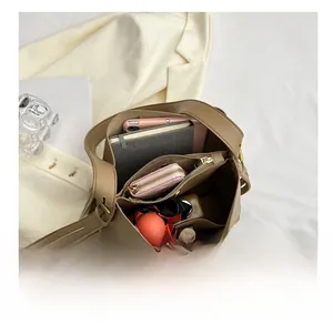 Detail view of large bucket bag interior with laptop, umbrella and organized compartments