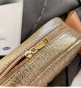 Detail of smooth metal zipper and gold wrinkled texture on fashionable crossbody bag