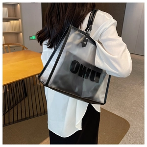 Bolso tote de PVC transparente con asas de cuero negro colgado al hombro en una biblioteca