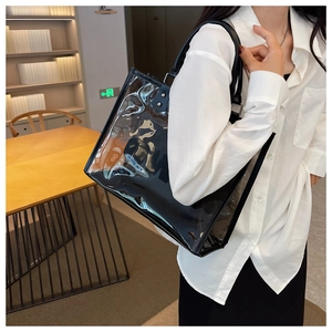 Detalle del bolso tote de PVC transparente con neceser interior negro y asas circulares