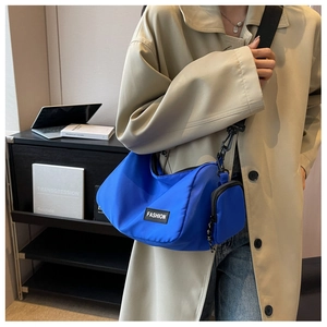 Bright blue nylon crescent crossbody bag with mini pouch on a stylish wide black strap