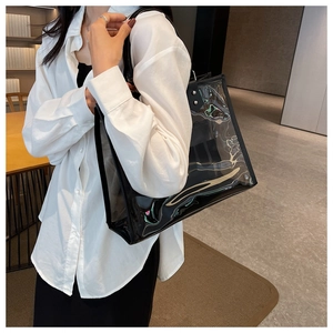 Detalle del bolso tote de PVC transparente con ribete de cuero negro y estuche