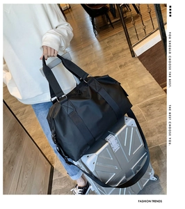 Detail der schwarzen Oxford-Reisetasche am Koffergriff mit verstellbarem Schultergurt