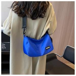 Detail view of Klein blue nylon crescent bag with adjustable wide shoulder strap