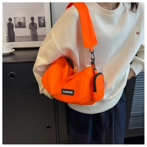 Detailed macro view of orange nylon crossbody bag with detachable mini pouch and strap