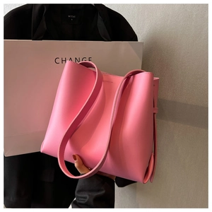 Detail of a bright pink leather tote bag featuring a minimalist design and large capacity