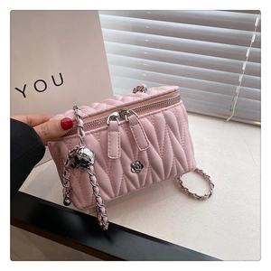 Detailaufnahme der rosa gesteppten Tasche mit silberner Kette und Kamelien-Verzierung