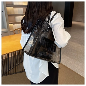 Bolso tote transparente negro moderno con asas de cuero mostrado en escena cotidiana