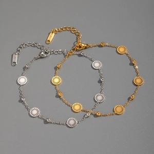 Detail of gold and silver stainless steel bracelets with sun flower charms and small beads