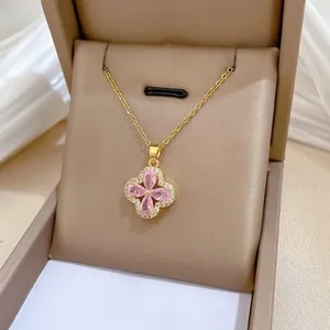 Macro view of four-leaf flower pendant with pink stones and white crystals in gift box