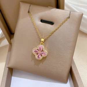 Macro shot of titanium steel clover necklace with pink crystals and zircon border