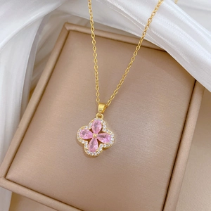 Detailed close-up of a pink clover pendant with micro-pave zircons on a gold chain