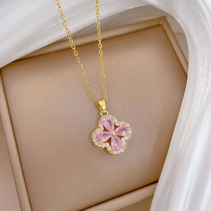 Close-up of gold clover pendant with pink pear-cut crystals and pavé zircon details