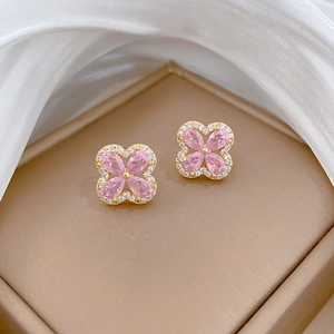 Detail of four-leaf clover stud earrings with pink marquise zircon and gold plating