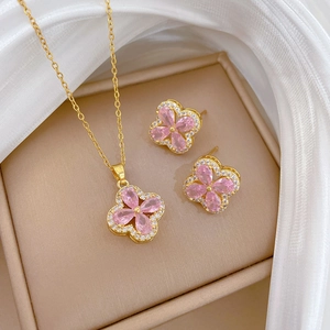 Detail of pink crystal clover jewelry set in a luxury beige leather gift box