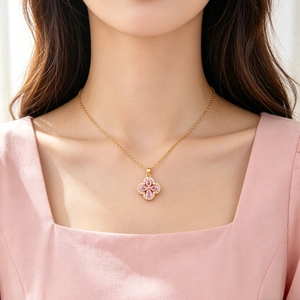 Detail of pink crystal flower pendant on a thin gold titanium steel necklace worn by model
