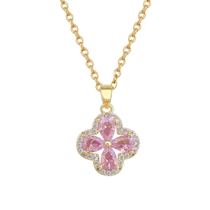 Detailed macro of pink clover pendant with micro-pave crystals on gold necklace