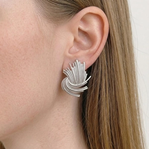 Silver vintage sunburst textured stud earrings in stainless steel on female model