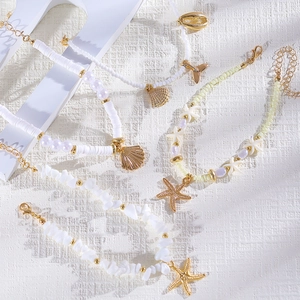 Detalle del conjunto de tobilleras con cuentas de estrella de mar y conchas de mar