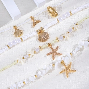 Detalle de cerca del conjunto de tobilleras de estilo playa con estrellas de mar y perlas