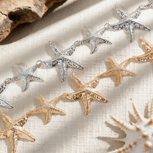 Detailaufnahme von Seestern-Taillenketten in Gold und Silber mit Hammerschlag-Textur